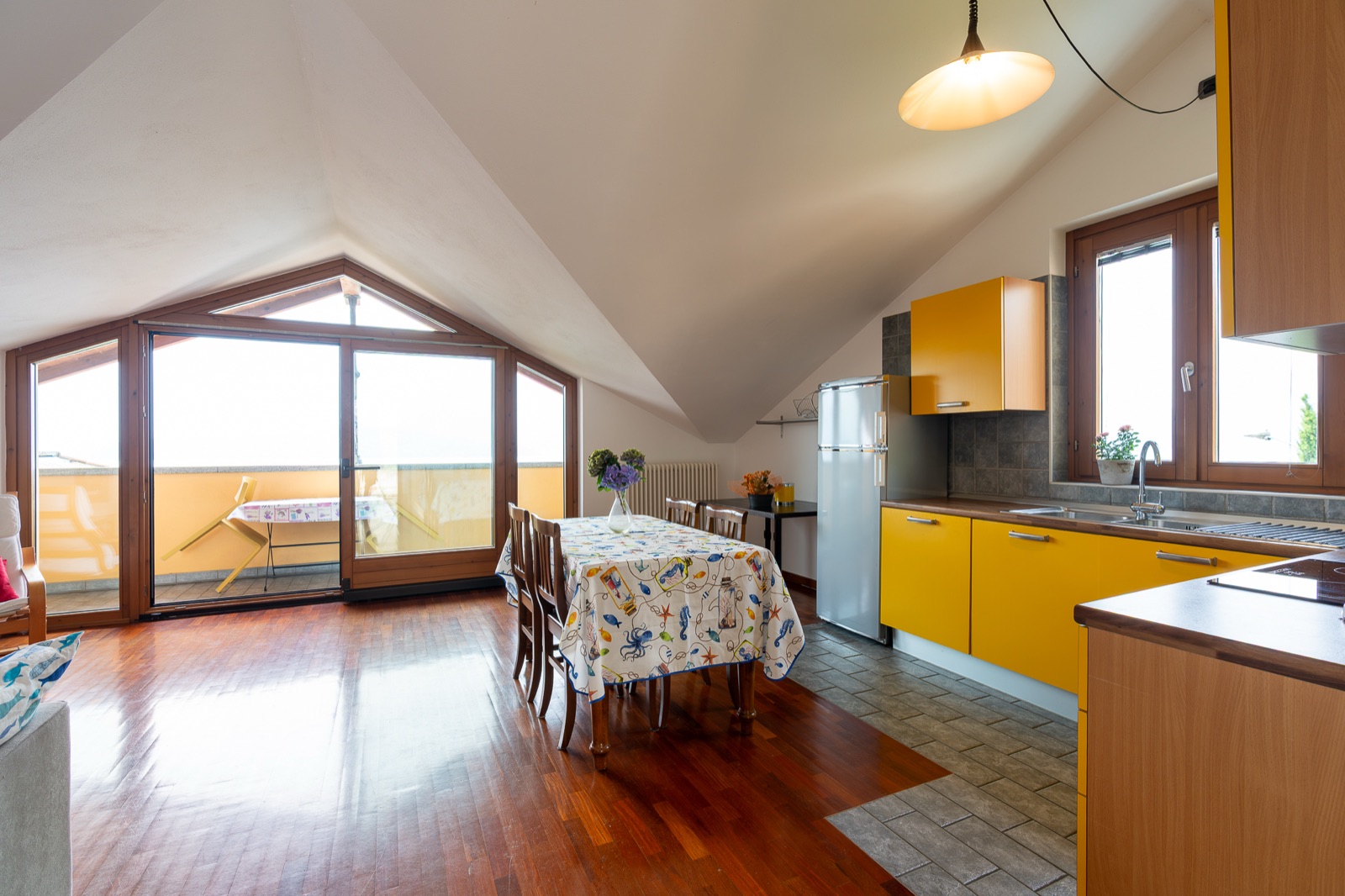Offener Wohnbereich mit Glastüren zur Terrasse und Küche