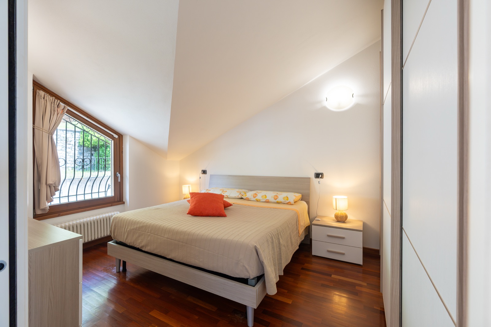 Schlafzimmer mit Doppelbett und Fenster unter der Dachschräge